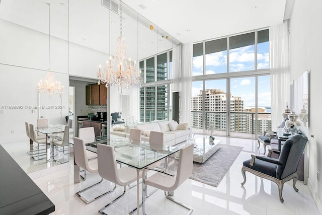 dining space with a notable chandelier, expansive windows, light tile patterned floors, and a high ceiling