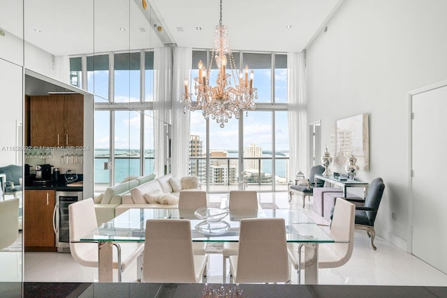 dining room with a notable chandelier, light tile patterned flooring, a wealth of natural light, and expansive windows