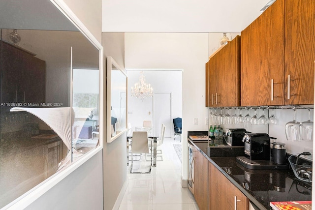 kitchen with dark stone countertops, light tile patterned flooring, and a chandelier