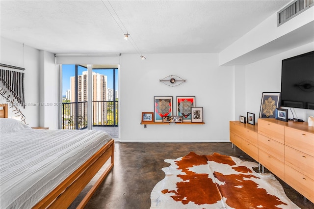 bedroom with access to outside and a textured ceiling