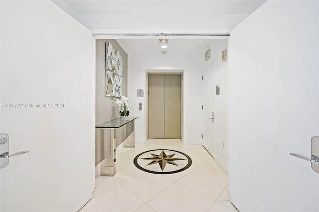 hall featuring elevator and light tile patterned floors