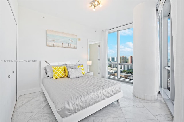 bedroom featuring a view of city, baseboards, access to exterior, and marble finish floor