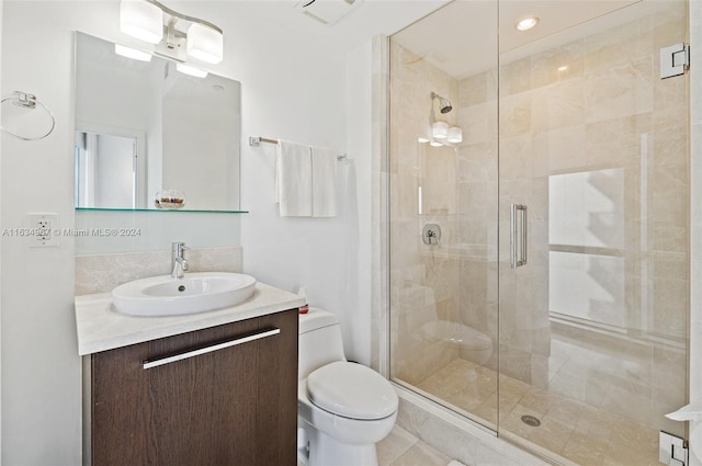 bathroom with tile patterned floors, walk in shower, vanity, and toilet