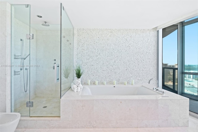 bathroom with shower with separate bathtub, a wealth of natural light, a water view, and tile patterned flooring