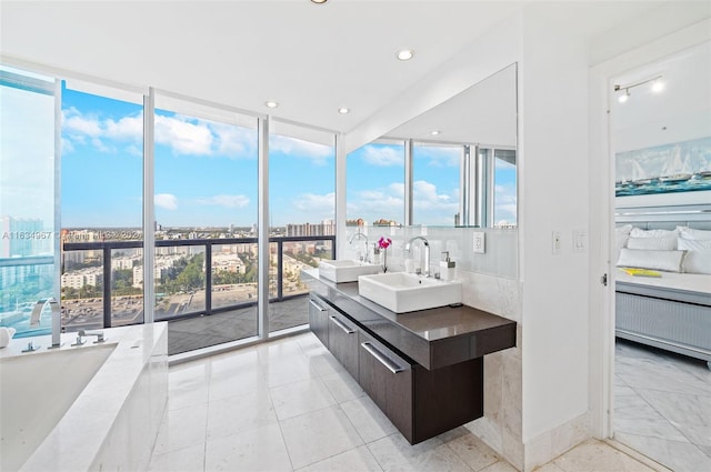 bathroom with double sink vanity, floor to ceiling windows, tile patterned flooring, decorative backsplash, and a tub to relax in