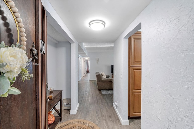 corridor with light hardwood / wood-style floors