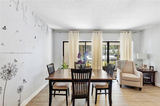 dining area featuring a textured ceiling and light wood-type flooring