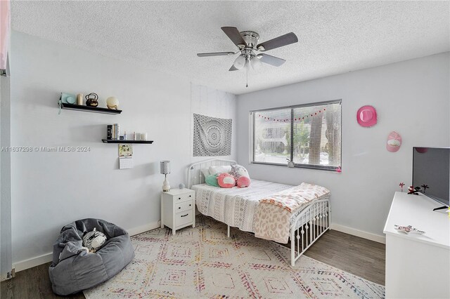 bedroom with a textured ceiling, light hardwood / wood-style flooring, and ceiling fan