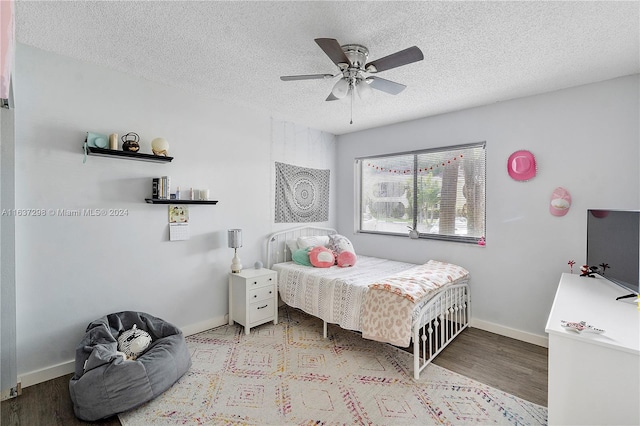 bedroom with ceiling fan, a textured ceiling, and light wood-type flooring