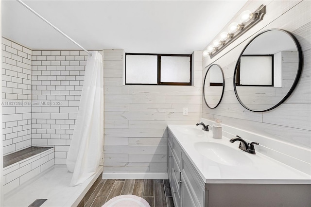 bathroom featuring tile walls, a shower with shower curtain, hardwood / wood-style floors, and double sink vanity