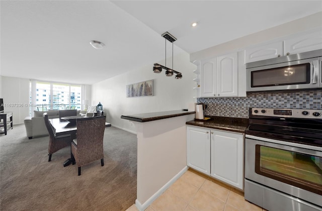 kitchen featuring light colored carpet, appliances with stainless steel finishes, white cabinets, and tasteful backsplash