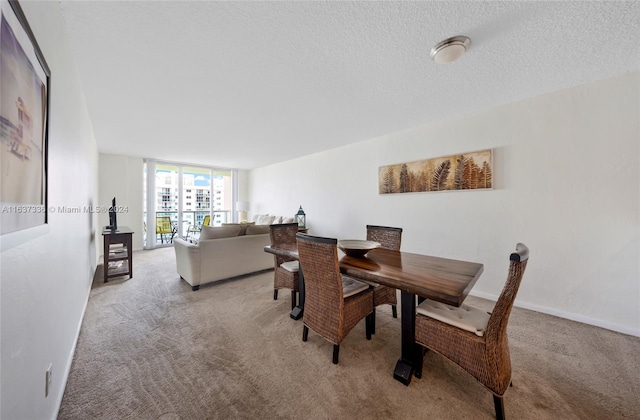 dining space with light carpet and a textured ceiling