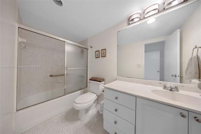 full bathroom with shower / bath combination with glass door, vanity, toilet, and tile patterned floors