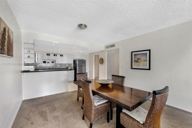 carpeted dining space featuring a textured ceiling