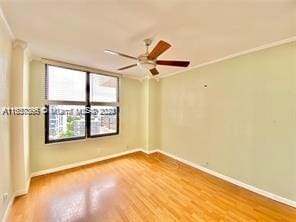 unfurnished room featuring light hardwood / wood-style floors, ornamental molding, and ceiling fan