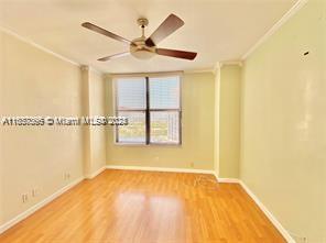 unfurnished room featuring crown molding, light wood-type flooring, and ceiling fan