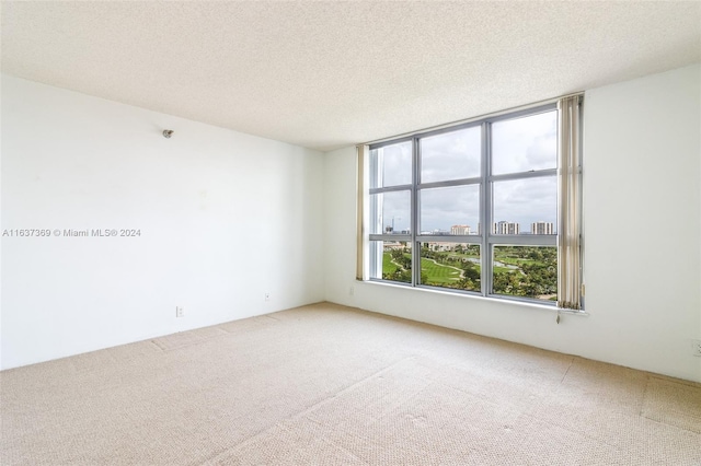 carpeted empty room featuring a textured ceiling