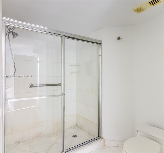 bathroom featuring walk in shower and toilet