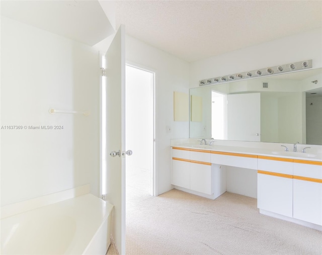 bathroom with dual vanity, a textured ceiling, and a bathing tub