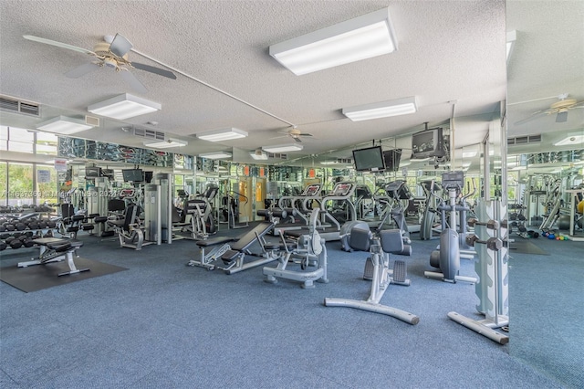 exercise room with a textured ceiling, carpet floors, and ceiling fan