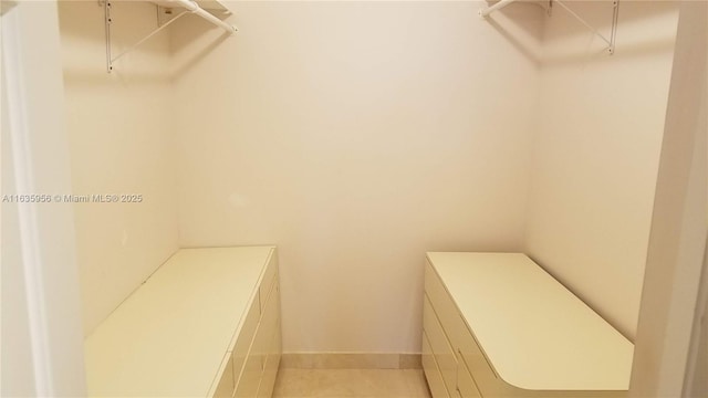 spacious closet with light tile patterned floors