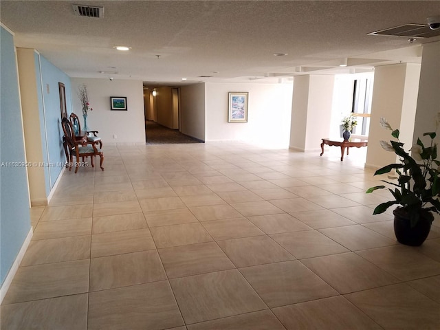 unfurnished room with light tile patterned floors and a textured ceiling