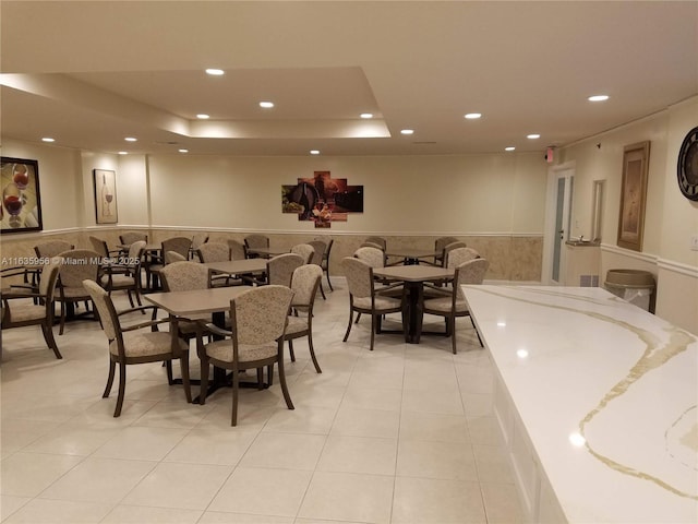 dining room with light tile patterned floors and a raised ceiling