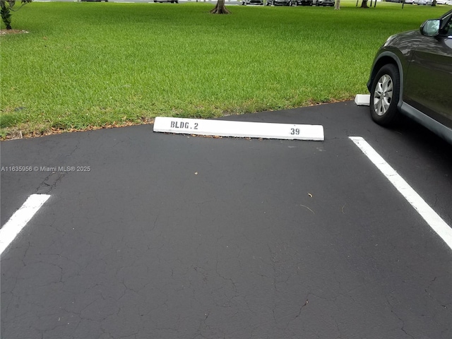 view of parking / parking lot with a lawn