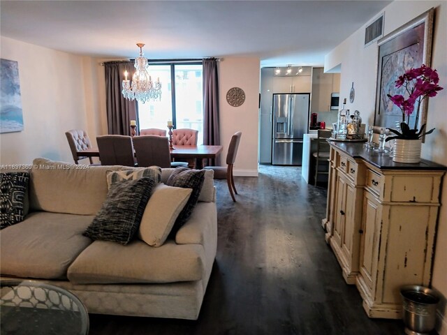 living room with dark wood-type flooring and a chandelier