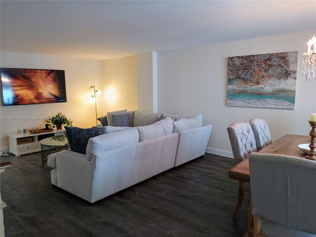 living room with a chandelier and dark hardwood / wood-style floors