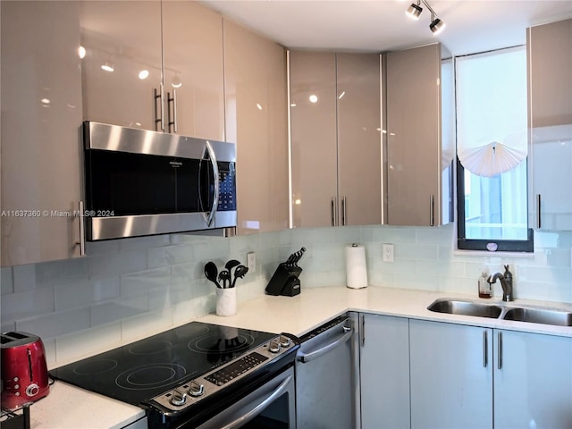 kitchen with gray cabinets, tasteful backsplash, appliances with stainless steel finishes, and sink