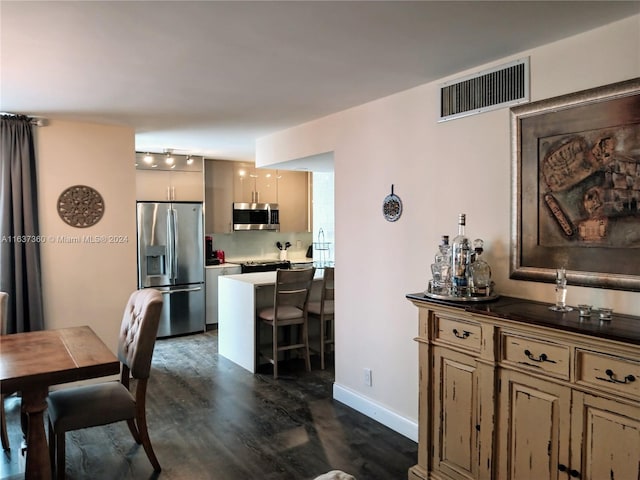 dining space featuring dark hardwood / wood-style flooring and rail lighting