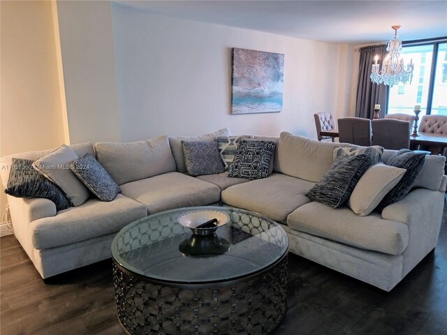 living room with dark wood-type flooring and a chandelier