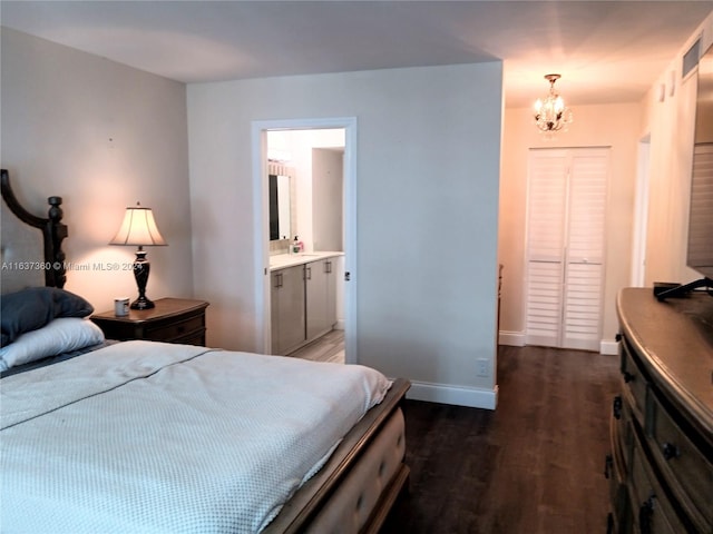 bedroom with a notable chandelier, dark hardwood / wood-style flooring, and ensuite bathroom