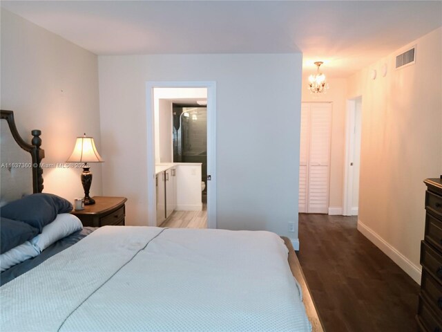 bedroom with an inviting chandelier and hardwood / wood-style floors