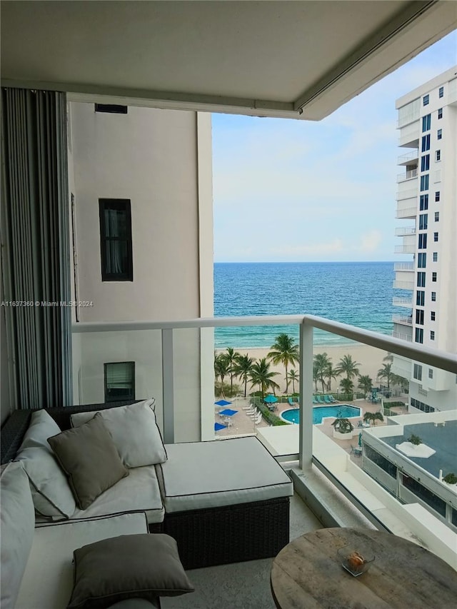 balcony featuring an outdoor living space, a water view, and a community pool