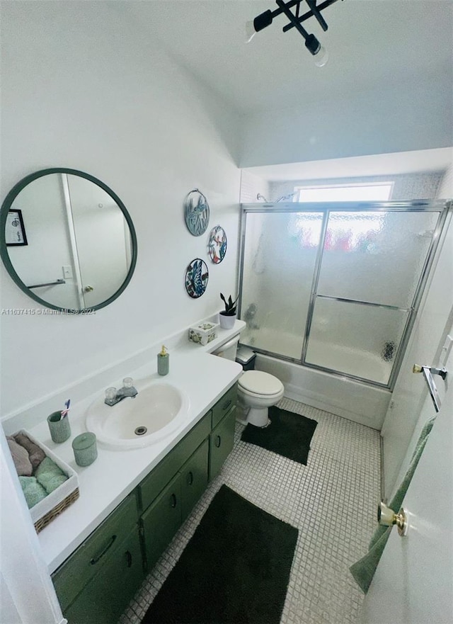 full bathroom with vanity, tile patterned flooring, bath / shower combo with glass door, and toilet