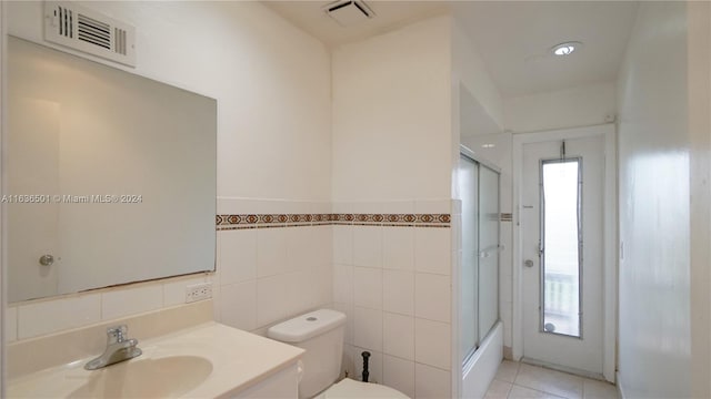 bathroom with combined bath / shower with glass door, vanity, visible vents, and tile patterned floors