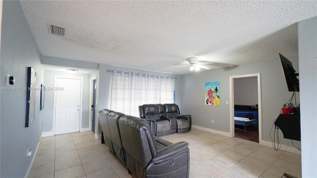 living room featuring light tile patterned floors, ceiling fan, visible vents, and baseboards