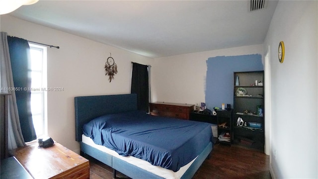 bedroom featuring visible vents and dark wood-style flooring