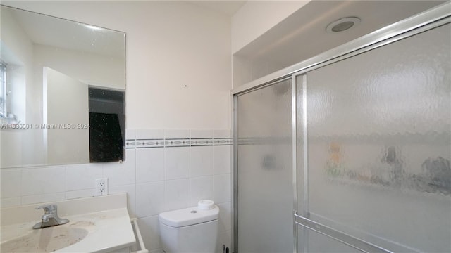 full bath featuring toilet, a shower stall, vanity, and tile walls