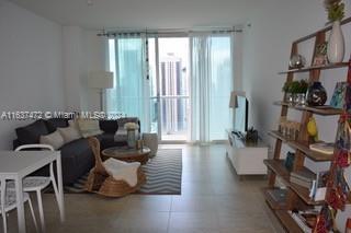 living room with a healthy amount of sunlight and tile patterned floors