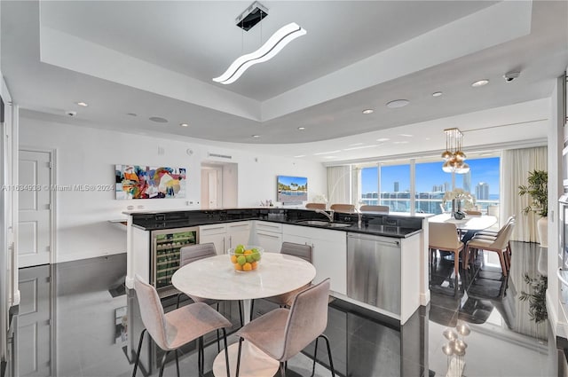 kitchen featuring a view of city, a peninsula, dark countertops, and decorative light fixtures