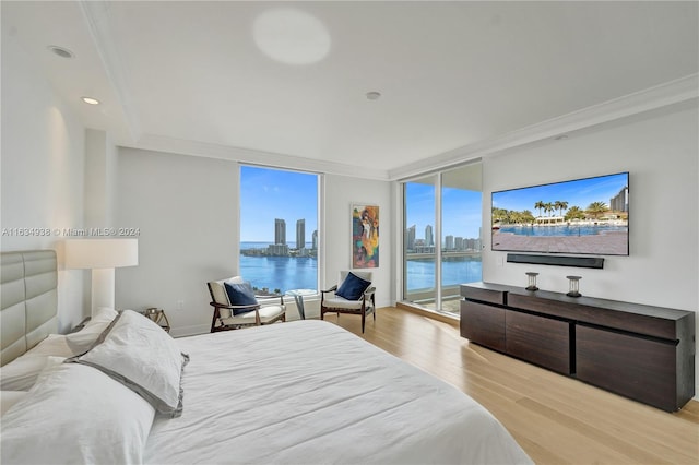 bedroom with light wood-type flooring, a wall of windows, access to outside, and crown molding