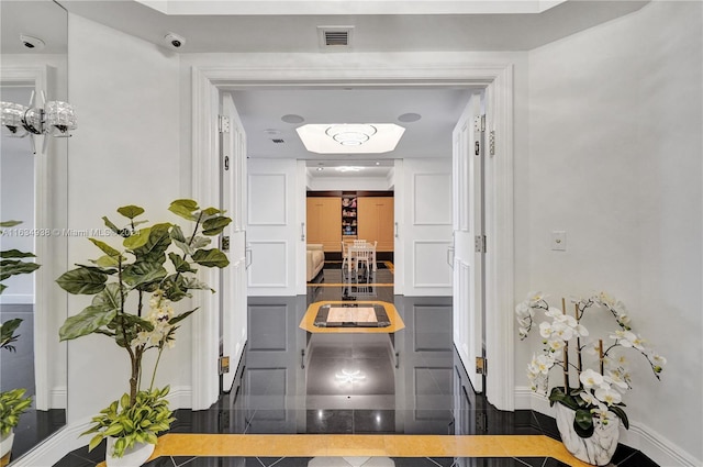 corridor with visible vents, granite finish floor, and baseboards