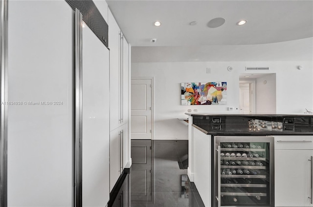 kitchen featuring tile patterned floors, wine cooler, and white cabinetry