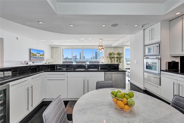 kitchen featuring white microwave, beverage cooler, dark stone countertops, dishwasher, and wall oven