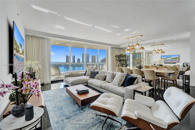 living room featuring floor to ceiling windows, a water view, and an inviting chandelier