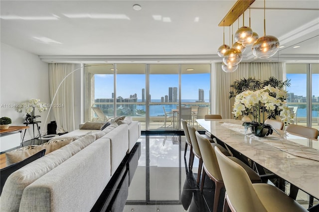 dining room featuring a view of city, a wall of windows, and a water view