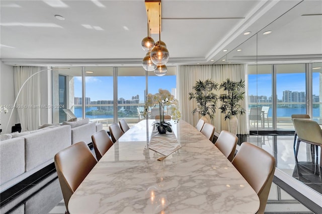 dining space with floor to ceiling windows and a water view